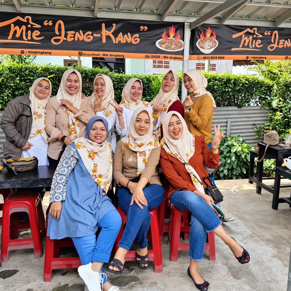 Rombongan pelanggan berhijab berfoto di depan spanduk Mie Jeng-Kang